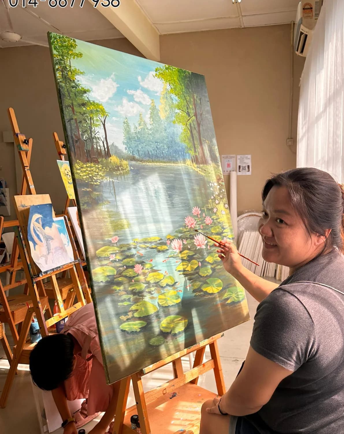 Artist painting a large canvas landscape in Rycca Painting Class studio