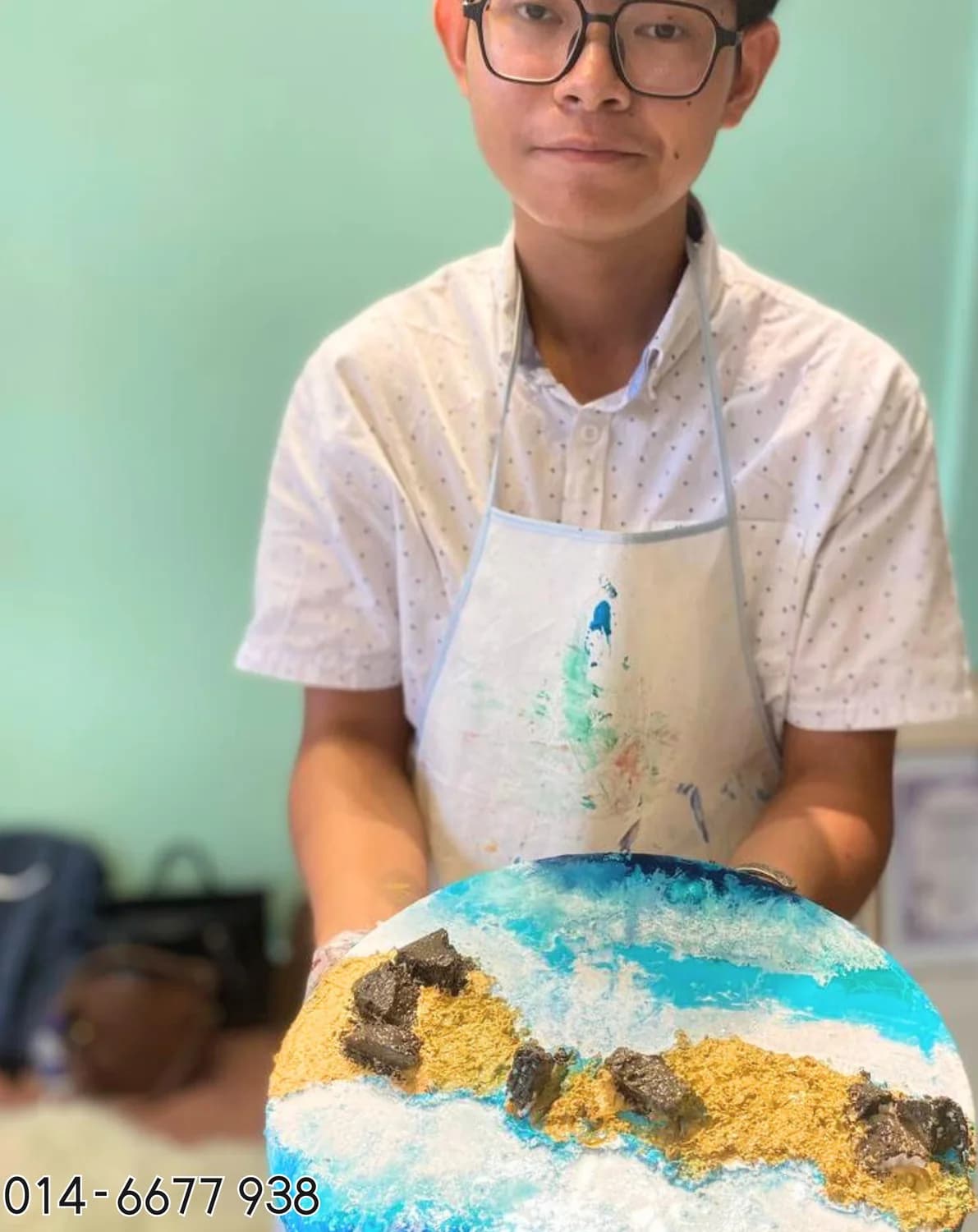 Boy holding round ocean texture art from Rycca painting class