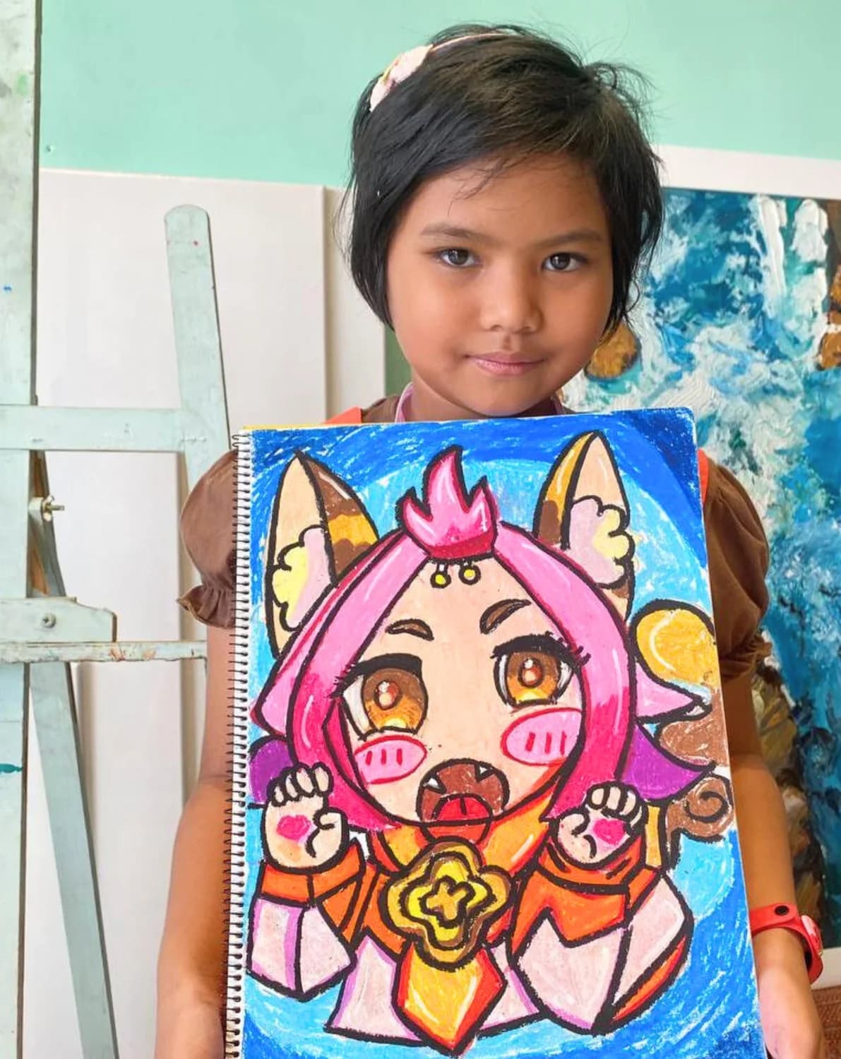 Girl holding unicorn character painting from Rycca creative art class