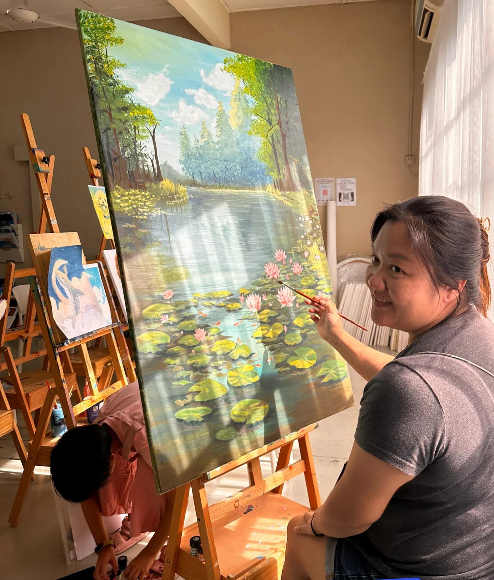 Rycca Painting Class student painting a large landscape canvas in Sungai Long